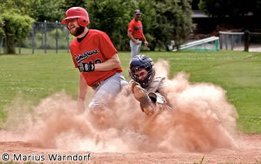 Bruno Albrecht of the Rainbows is called out on a tag at home by catcher Sanders.